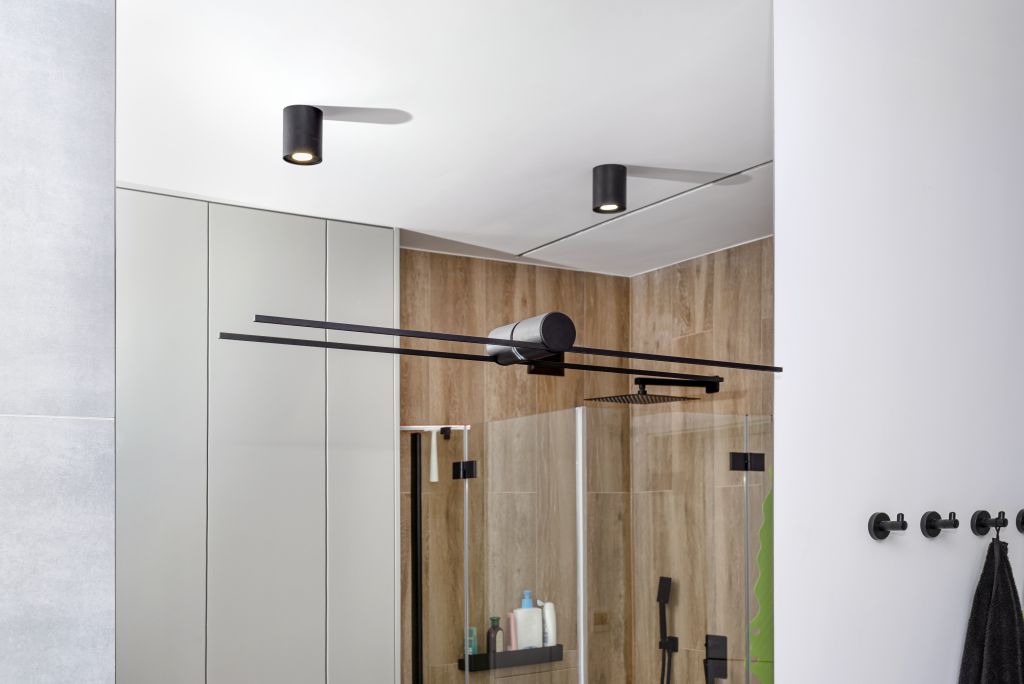 black-sconce-mounted-large-mirror-bathroom-visible-led-lighting-shape-tube.jpg